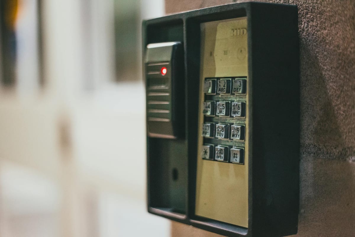Illuminated security keypad with access control panel on a wall