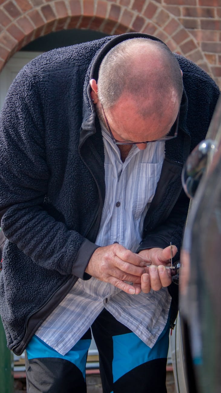 Licensed locksmith technician working on a door lock during a service call