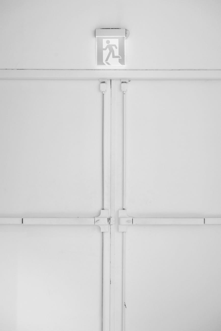 Double doors with exit device hardware and illuminated exit sign above