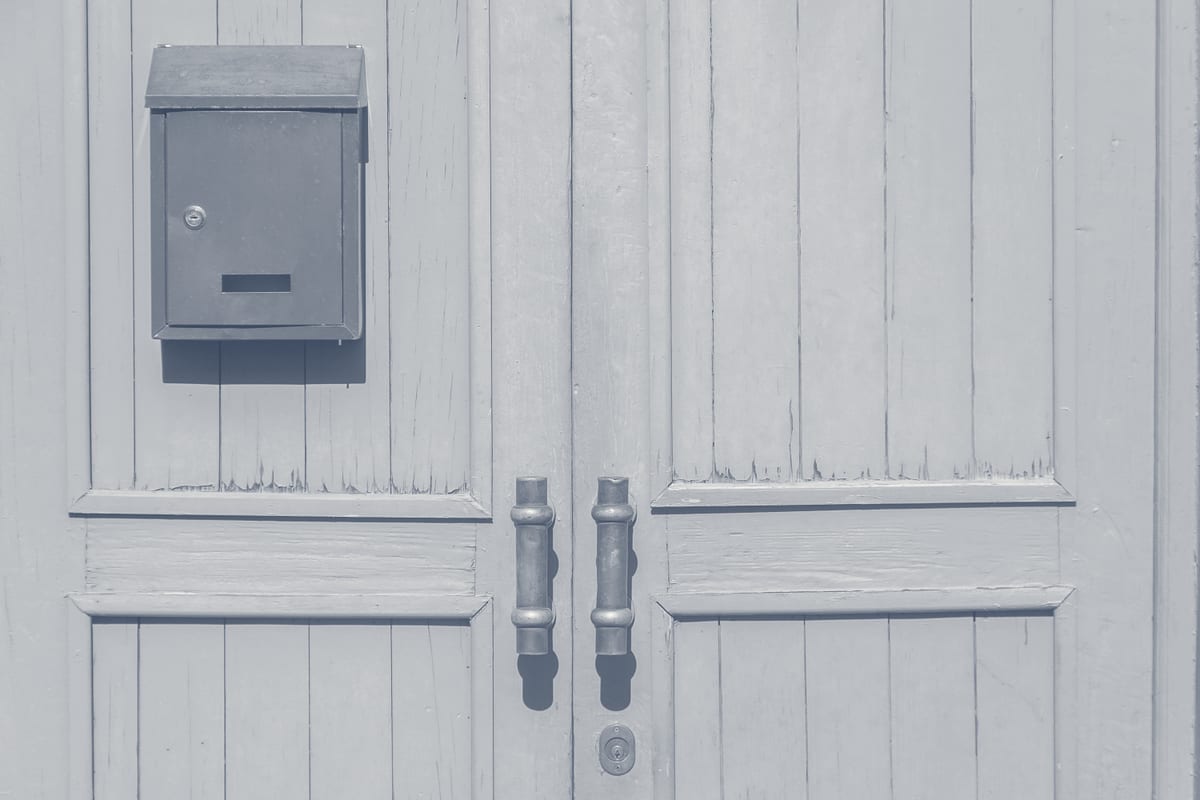 Brass door handles on residential entry with mail slot showing combined entry and mail hardware