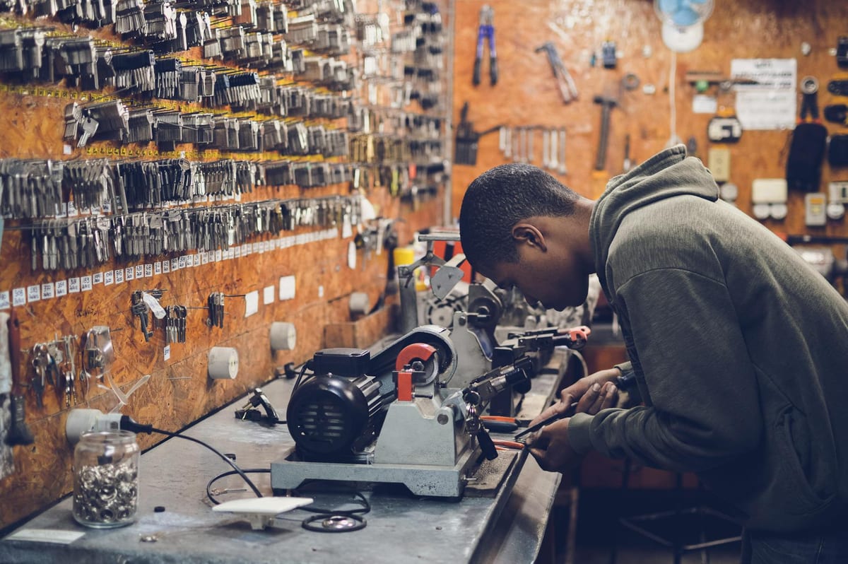 Locksmith craftsman operating a key cutting machine in a professional shop